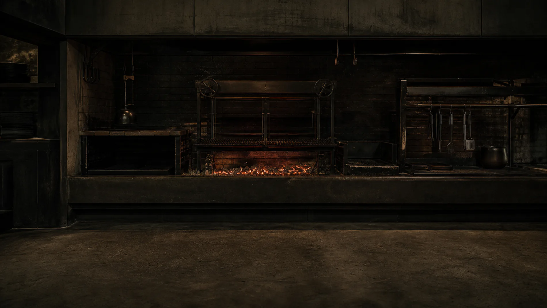 The empty live-fire kitchen after service with a final bed of glowing embers.